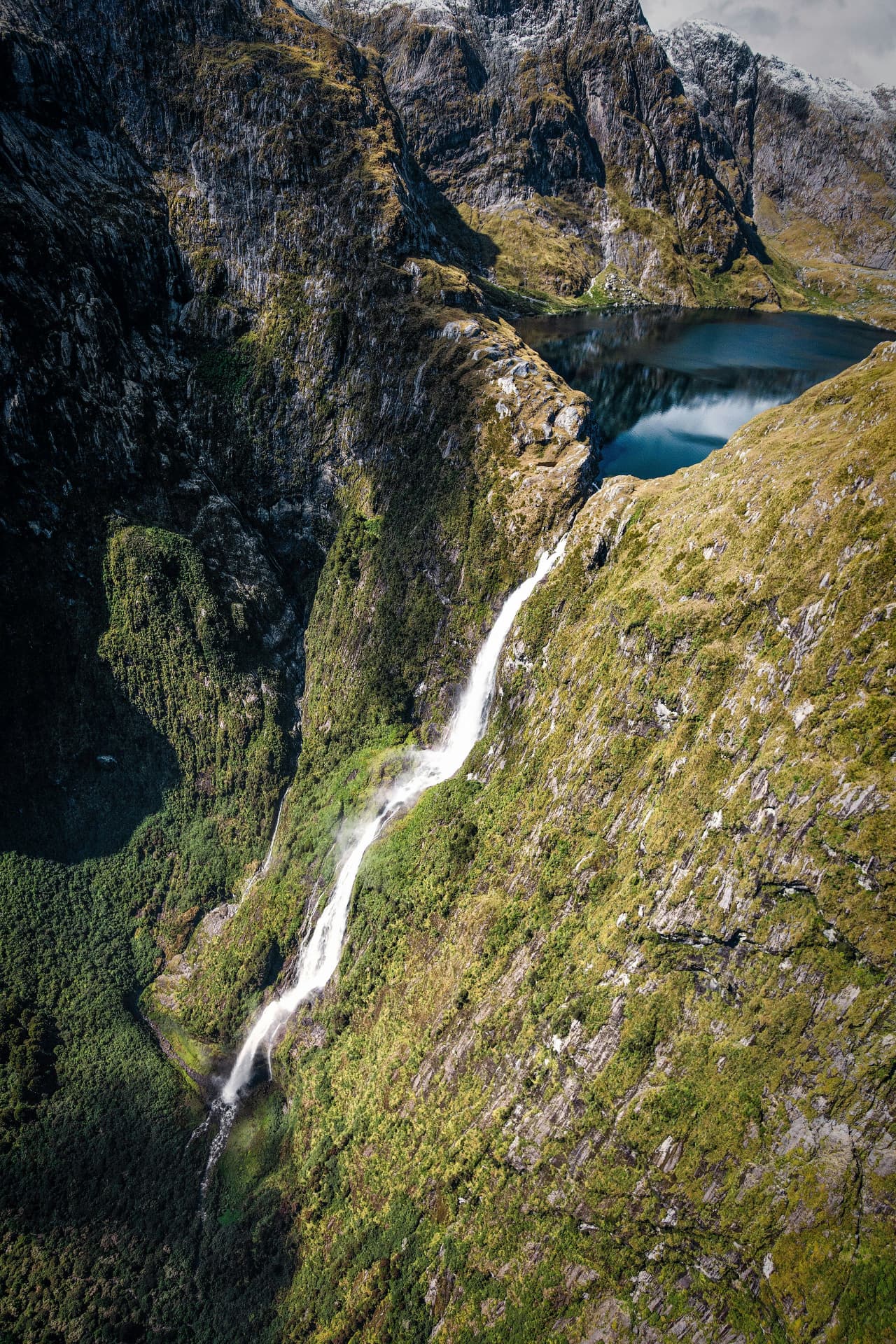 Towering waterfall dropping from a hanging lake in Fiordland