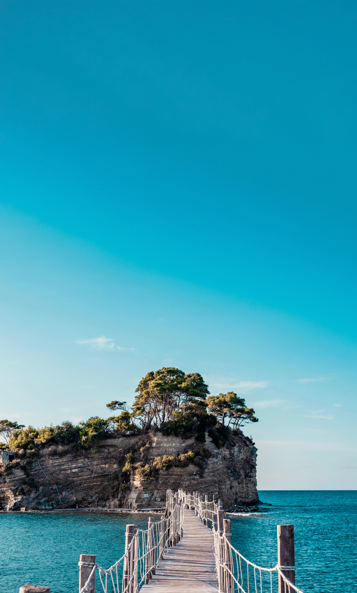 Wooden bridge to a light-drenched rocky islet