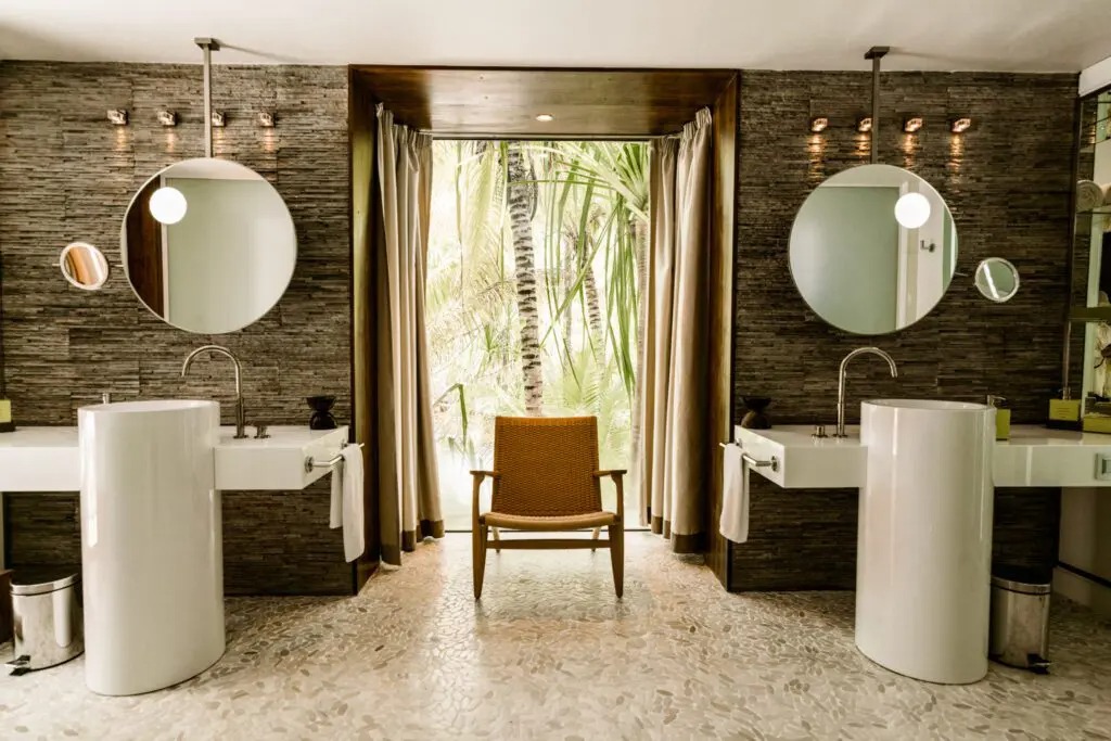 Salle de bains d'une villa de The Brando ouverte sur la végétation
