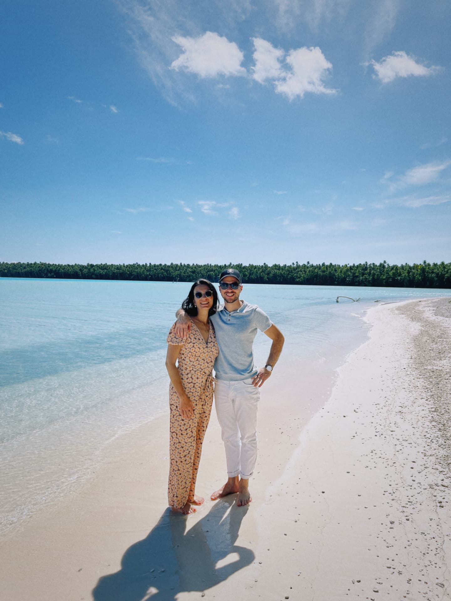 Couple sur une plage de sable blanc bordée d'un lagon turquoise à Tetiaroa