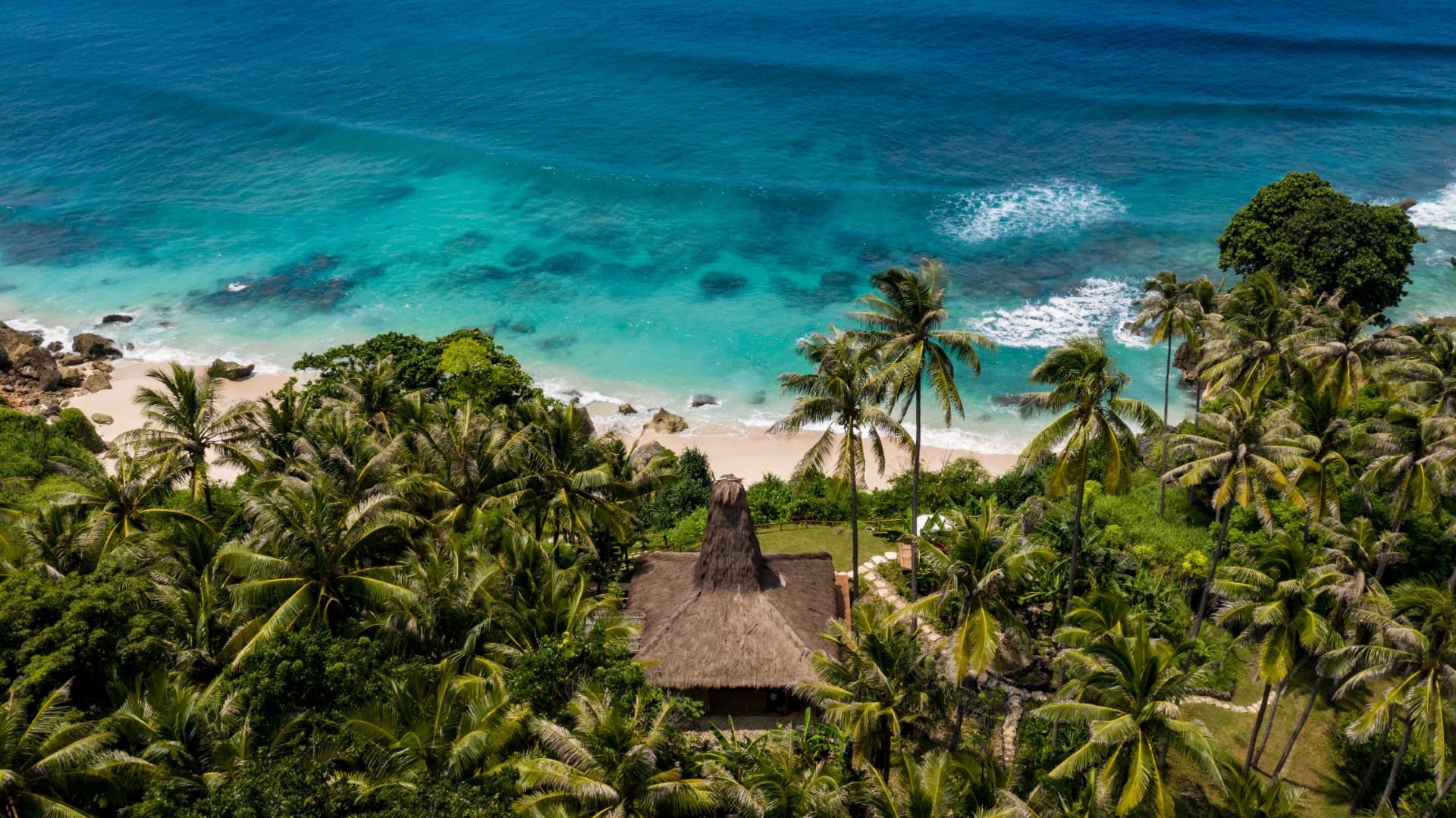 Chevaux et accompagnateurs dans les eaux de Nihiwatu à Sumba