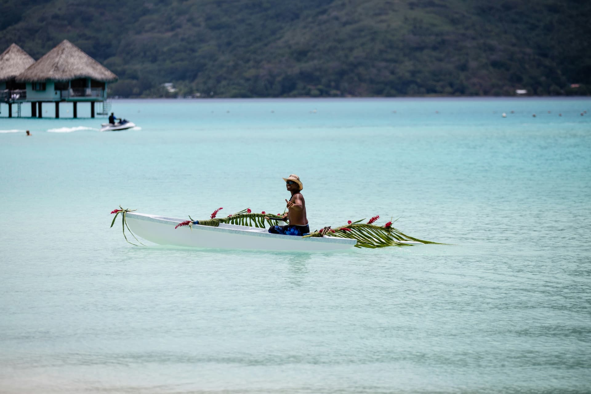 Traditional flower-decked outrigger canoe on the Bora Bora lagoon