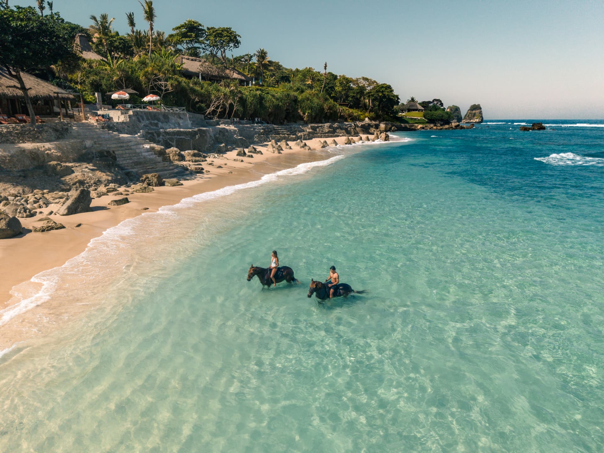 Chevaux courant sur la plage de Nihiwatu à NIHI Sumba